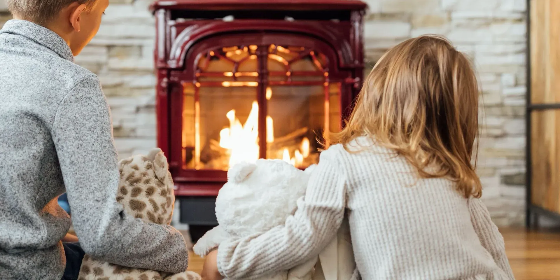 Two kids warming by the fire on a cozy Montana morning